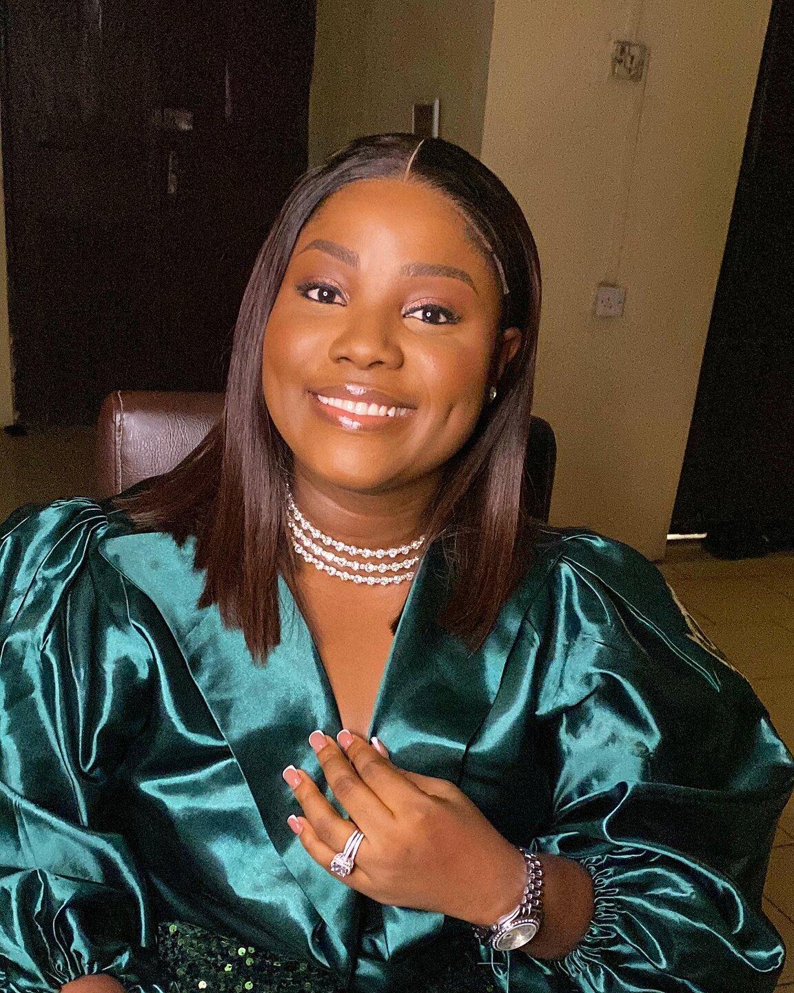 Client in an emerald satin outfit with luminous makeup