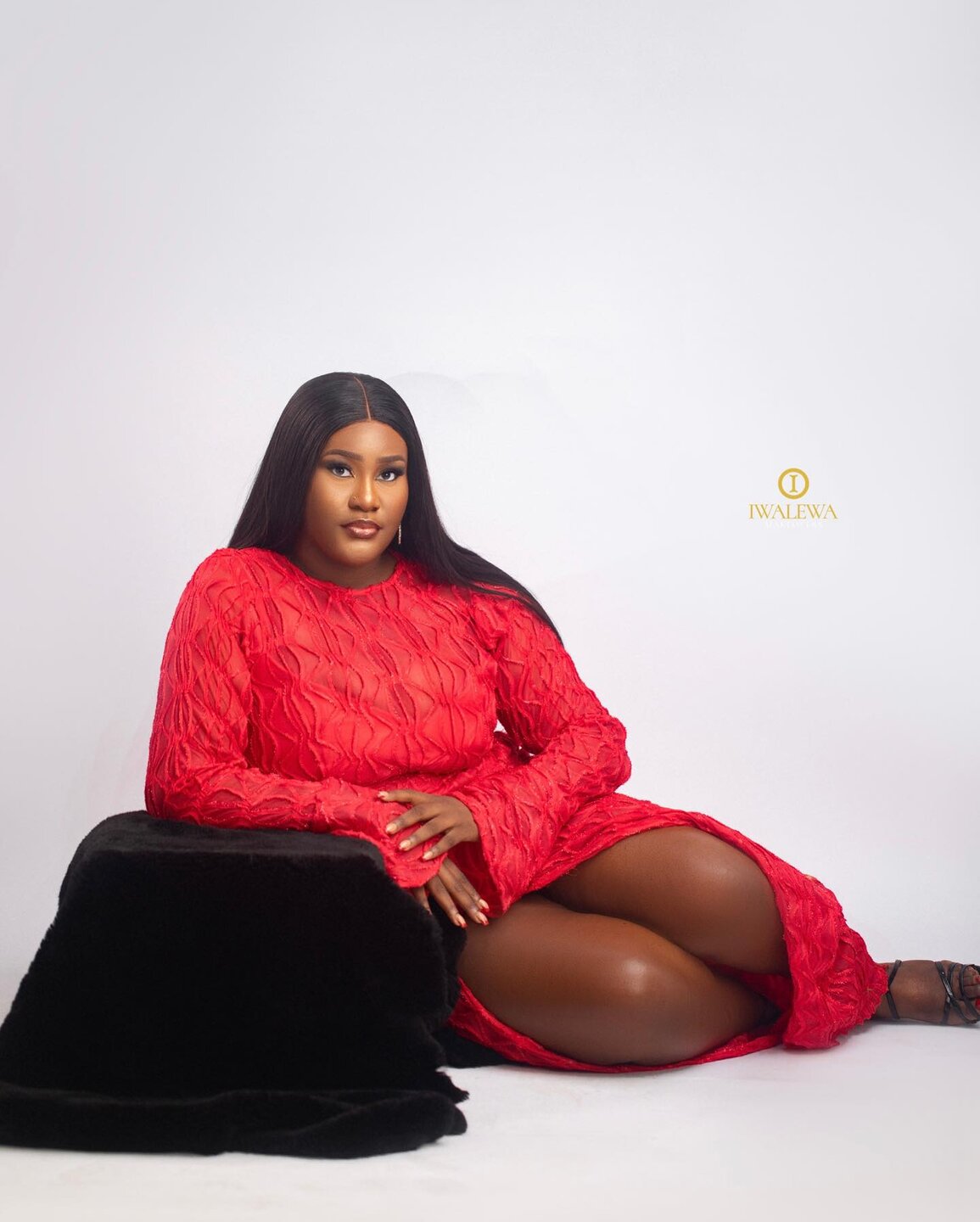 Client in a red textured dress with sleek straight hair and polished makeup
