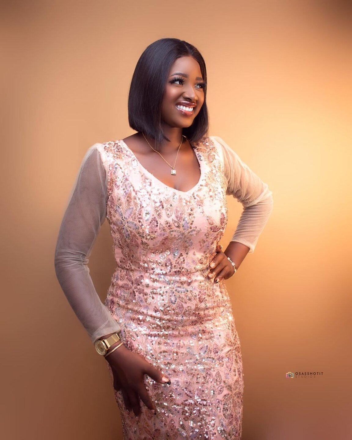 Smiling client in a pink sequin dress with a soft glam finish